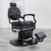 barber chair for sale Blackout barber chair in matte black vinyl with a tufted backrest, black powder-coated hydraulic base, and reclining handle.