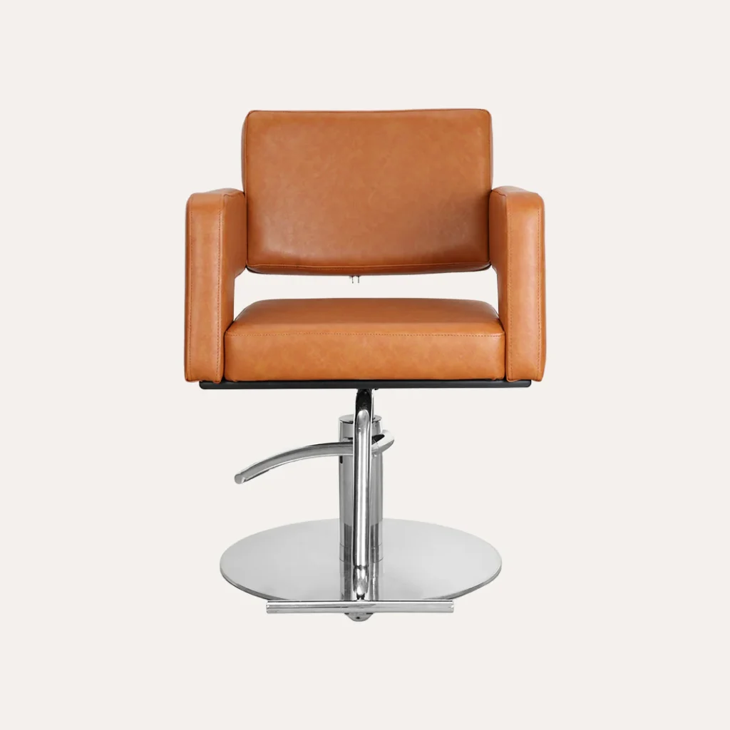 A cozy and sophisticated modern salon seating arrangement, featuring plush armchairs upholstered in rich leather, arranged in a symmetrical layout against a backdrop of sleek, minimalist decor. Warm lighting casts a soft glow, creating an inviting atmosphere. The chairs are positioned around a low, polished wooden coffee table, creating an intimate conversation area. In the foreground, a branded sign reads "James Barber Shop", subtly incorporating the business name. The overall scene conveys a sense of comfort, style, and professionalism, perfectly suited for a high-end beauty salon.